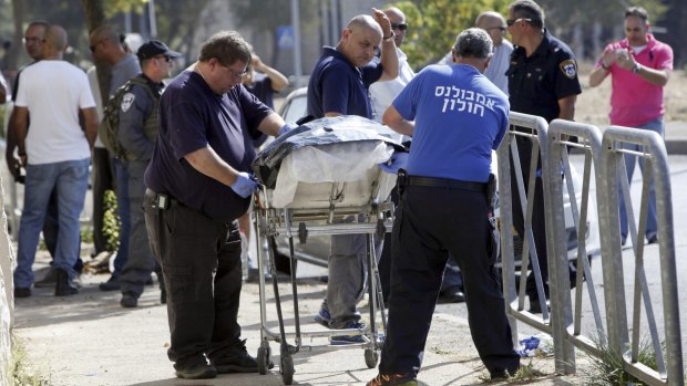 The body of an alleged Palestinian attacker is removed from the scene in Jerusalem on Saturday.