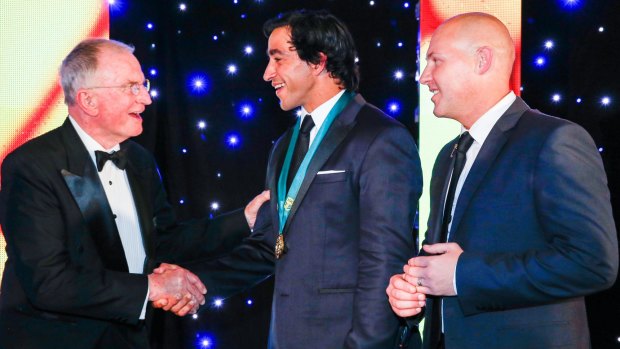 Dally Messenger III, left, presents the Dally M award to Johnathan Thurston in 2015.