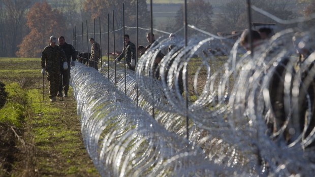 Slovenian soldiers erect razor-wire on the Croatian border in Gibina.