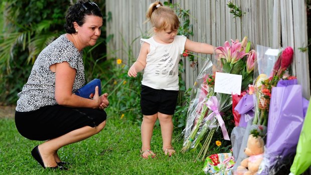 Members of the Cairns community leave flowers.