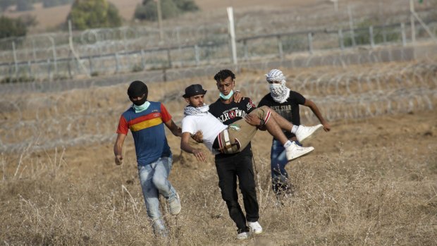 Palestinian protesters evacuate a wounded youth during clashes with Israeli soldiers by the Israeli border with Gaza last month.