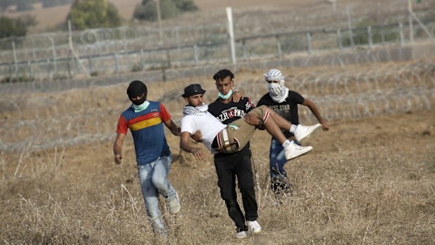 Palestinian protesters evacuate a wounded youth during clashes with Israeli soldiers by the Israeli border with Gaza last month.