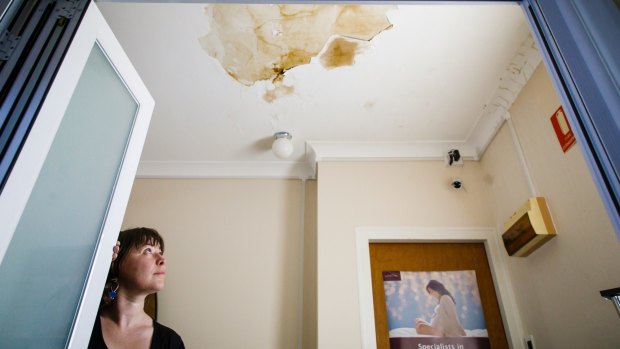 Emma Hely is frustrated by a leaky roof at her business in Ainslie. The building's heritage listing has prevented the building owner from making the repairs neccesary to fix the problem once and for all. 