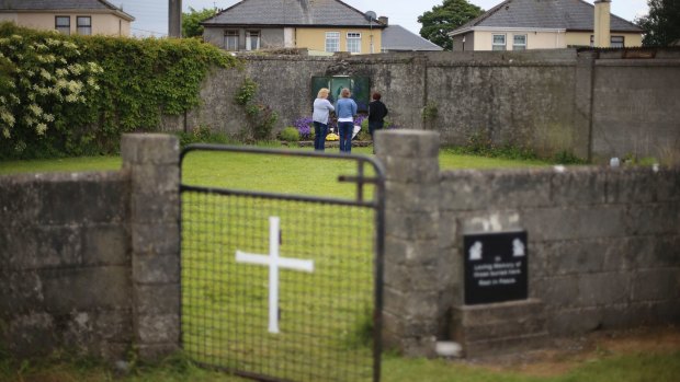Members of the public gather in memory of the children buried here at the site of a mass grave for babies who died in the Tuam mother and baby home in Ireland.