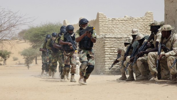 Nigerian special forces run past Chadian troops during a hostage rescue exercise.