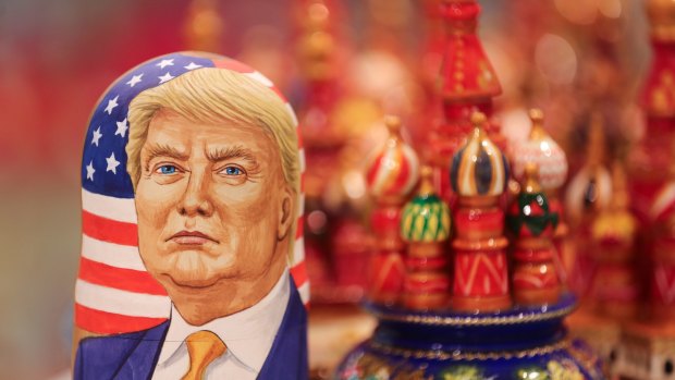 A matryoshka doll showing Donald Trump beside painted wooden models of St. Basil's cathedral in a souvenir shop in Moscow. 