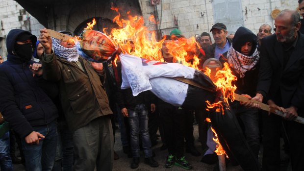 Palestinian protesters burn an effigy of US President Donald Trump during a protest against the decision to recognise Jerusalem as Israel's capital.