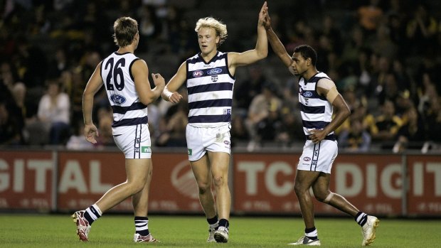 Tom Hawkins, Nathan Ablett and Travis Varcoe celebrate a goal.