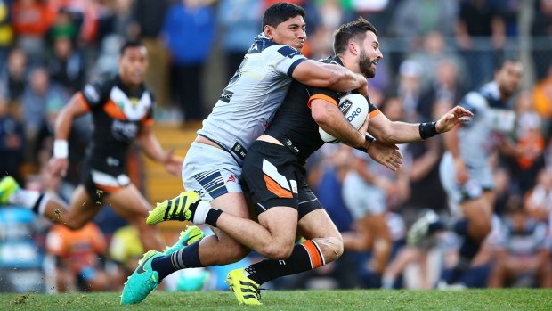 Jason Taumalolo of the Cowboys tackles James Tedesco of the Tigers at Leichhardt Oval on Sunday.