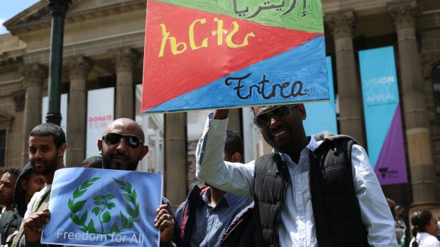 Protesters outside Melbourne's State Library  on November 5, 2017, with the Eritrean flag decorated in the English, Arabic and Tigrinya languages.