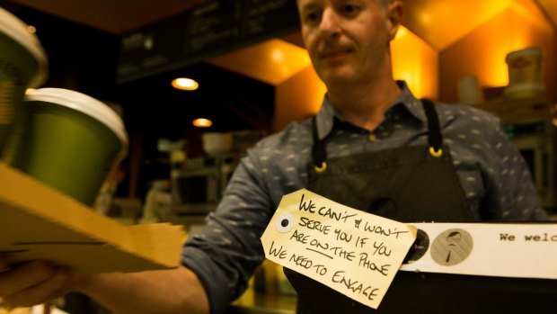 James English put a handwritten note on the cash register to ban mobile phones.