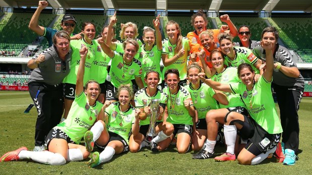 Canberra players and coaching support staff celebrate winning the 2014 W-League Grand Final.