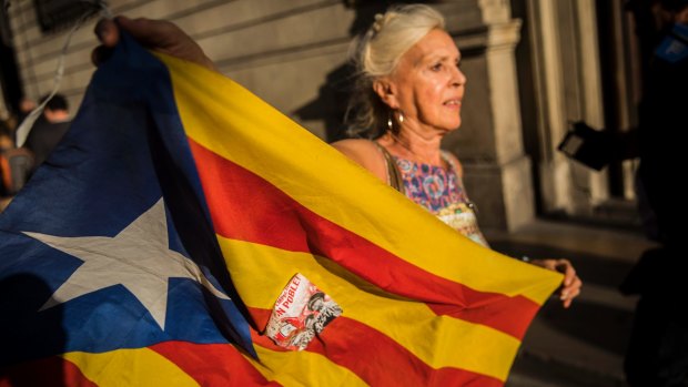 A woman waves an independence flag just after the speech of Carles Puigdemont's speech.