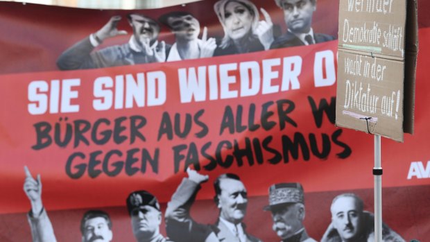 Anti-fascist demonstrators hold up a banner declaring 'They're back!'  showing photos of  dictators and fascists from the 20th century alongside some of the European leaders attending the meeting in Koblenz.