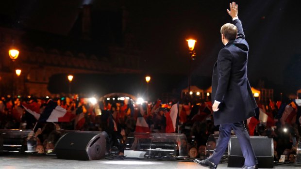 French President-elect Emmanuel Macron arrives on the stage at his victory rally near the Louvre museum.