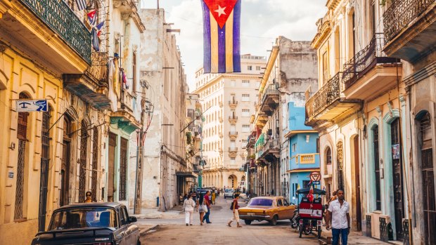 A Cuban flag waves over a street in central Havana. 
