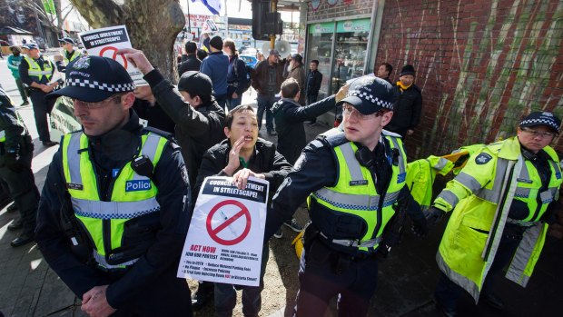 Demonstrators opposed to safe injecting rooms in Richmond are held back by police in Victoria Street in August.