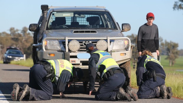 Police inspect the first vehicle involved in the Barnawartha North crash. 