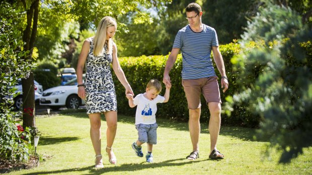 Ollie Lanham, who has cerebral palsy, with his parents, Angela Patch and Mark Laham, walking with help at home. The three-year-old recently had surgery in the US. 