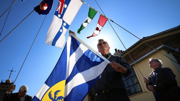 Flag designer John Vaughan and manufacturer Wayne Gregory (at right) hoist the flag of Lord Howe Island at Observatory Hill.