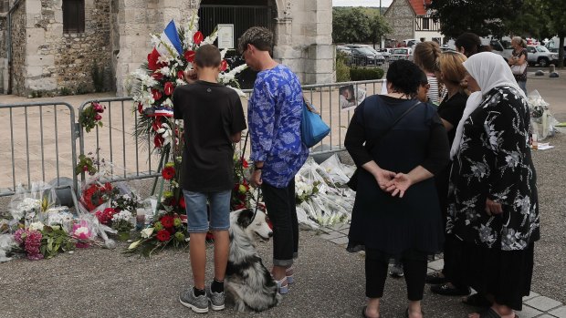 Residents pay tribute at a makeshift memorial in front of the Saint Etienne church where Priest Jacques Hamel was killed on 26 July.