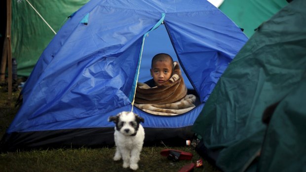 A boy sits inside a tent in Kathmandu.