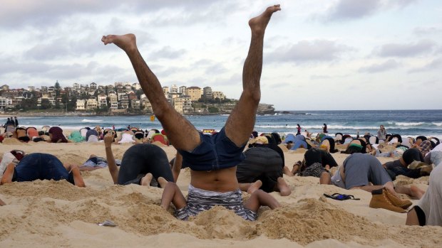 Denial: Australians burying their heads in the sands of Bondi Beach to send a message to Prime Minister Tony Abbott about the dangers of climate change. 