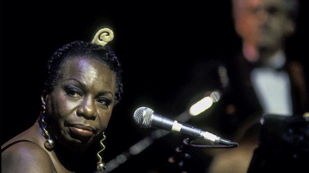 American musician and Civil Rights activist Nina Simone (born Eunice Kathleen Waymon, 1933 - 2003) performs at the Beacon Theater, New York, New York, May 1, 1993. Guitarist Al Shackman is visible, though out of focus, in the background. (Photo by Jack Vartoogian/Getty Images)