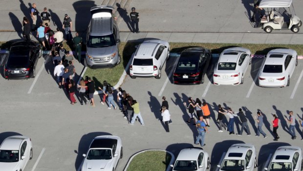 Students being evacuated by police from Marjorie Stoneman Douglas High School in Parkland, Florida last week.