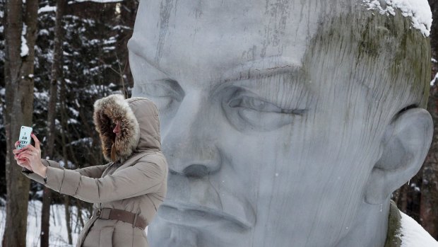 A woman takes a selfie with a statue of Lenin in a forest near Razliv Lake, outside St Petersburg.