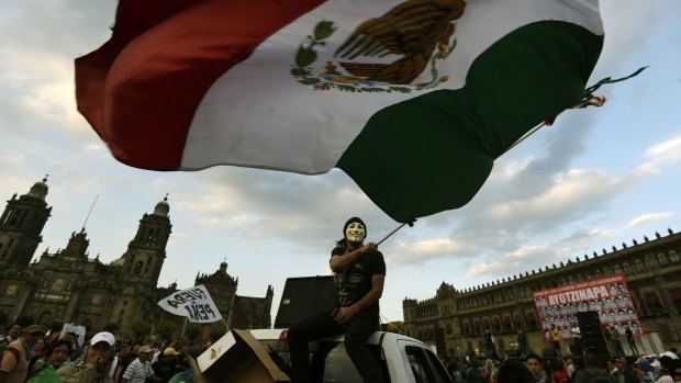People take part in a march commemorating four months of the disappearance of 43 students from Ayotzinapa, at the Zocalo square in Mexico City.