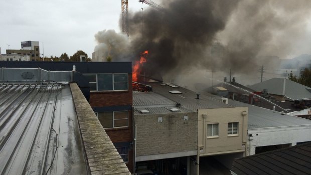 Flames break through the roof of a building on Alexander Street in Crows Nest.