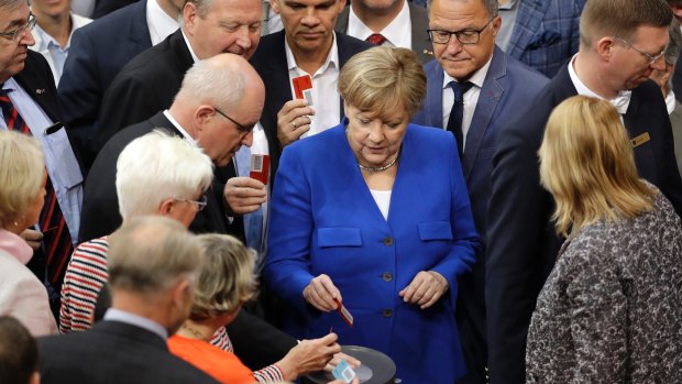 German Chancellor Angela Merkel casts her vote at the Bundestag after the same-sex marriage debate.