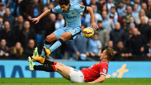 Out of his depth: 19-year-old Luke Shaw attempts to challenge City's Jesus Navas.