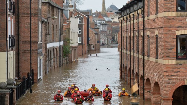 Members of the Mountain Rescue team wade through floodwater in Skeldergate, York, on Monday.