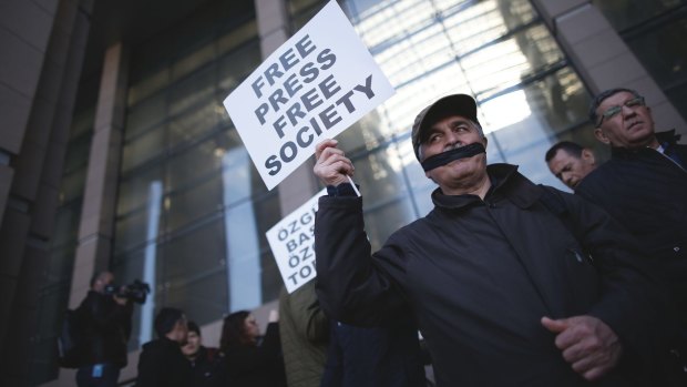 Turkish journalists cover their mouths with black ribbons before the trial of Can Dundar, the editor-in-chief of opposition newspaper Cumhuriyet, and Erdem Gul, the paper's Ankara bureau chief.