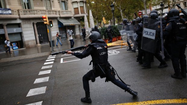 Spanish riot police shoots rubber bullet at people trying to reach a voting site at a school.