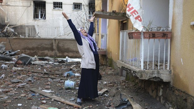 A woman cries in the compound of a destroyed police station in Cinar, in the mostly-Kurdish Diyarbakir province in southeastern Turkey.