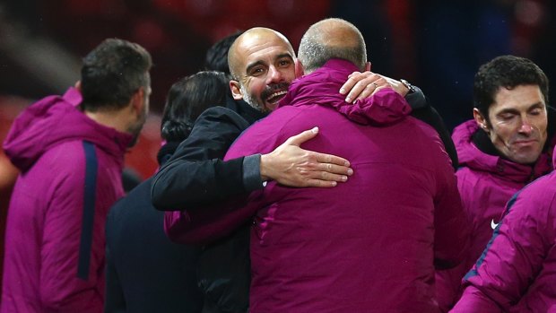 Manchester City coach Pep Guardiola celebrates with his team after the derby win.