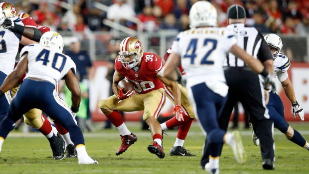Jarryd Hayne #38 of the San Francisco 49ers runs with the ball against the San Diego Chargers during their NFL preseason game in Santa Clara, California.