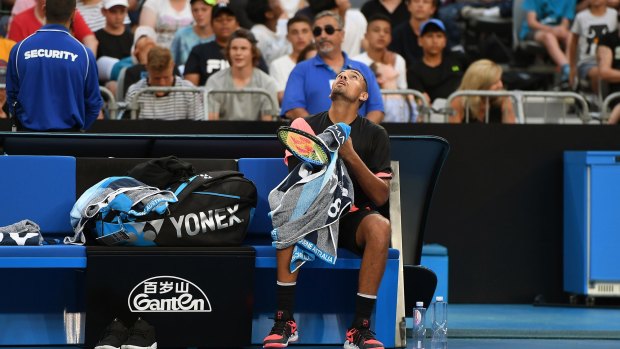 Making a racket: Nick Kyrgios checks out the helicopter hovering above court during a break in play against Viktor Troicki.