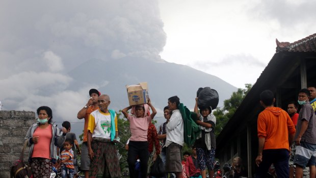 Villagers carry their belongings during an evacuation following the eruption of Mount Agung.