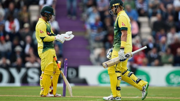Shane Watson walks back to the pavilion past teammate Matthew Wade after being run out