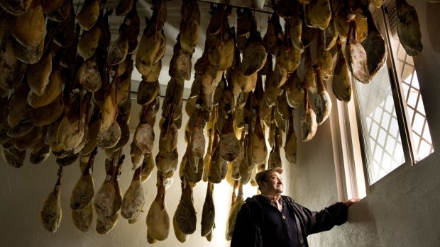 Faustino Prieto, owner of an Iberian ham business, with legs of dry-cured jamon iberico de bellota.