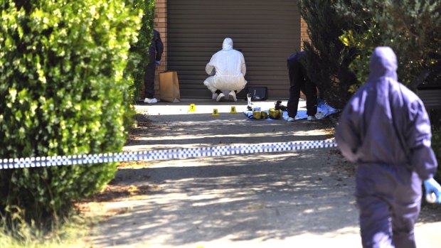 Forensic investigators process evidence in the driveway of the Wanniassa home where Neal Wilkinson was found dead in March.