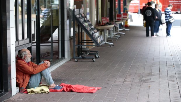 A man seeking help from passers-by in Garema Place.