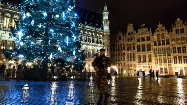 An armed soldier stands guard over the Grote Markt in Brussels on Monday. Security has been tightened in the nation's capital after police arrested 16 suspected terrorists during more than 22 anti-terror raids around the city on Sunday.