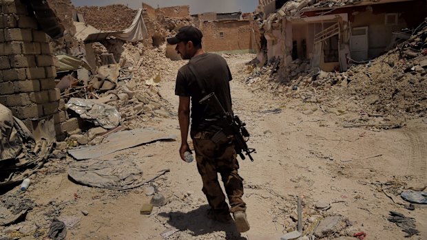 An Iraqi Special Forces soldier walks through the streets of West Mosul, Iraq, last week.