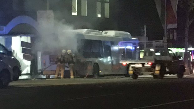 Firefighters extinguish a fire on a bus in George Street, Sydney, on Thursday night.