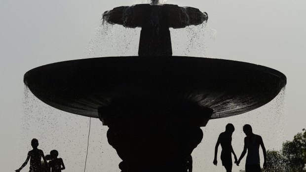Indian children play in a fountain near India Gate amid soaring temperatures in New Delhi.